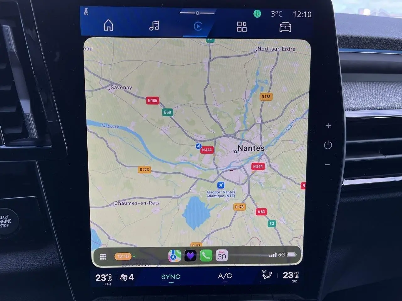 Écran central tactile du Renault Austral Ph.2 gris schiste montrant la navigation GPS sur Nantes, avec commandes climatisation visibles.