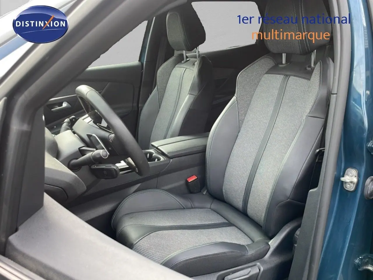 Vue intérieure côté conducteur du Peugeot 3008 1.6 Hybrid 2024, sièges tissu et cuir gris, portière bleu Celebes métal ouverte.