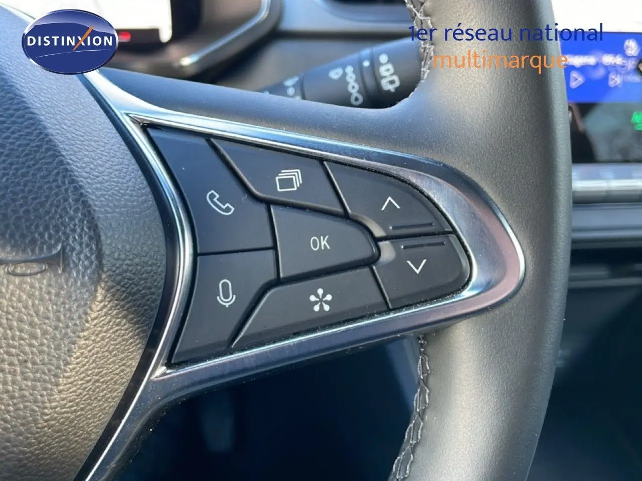 Gros plan sur les commandes au volant du Renault Captur 2025, boutons multifonctions avec finition noire et chrome.