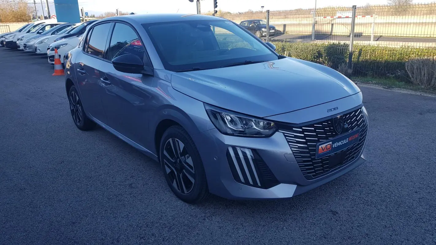 Peugeot 208 Hybrid gris vue 3/4 avant droit, avec calandre noire et jantes alliage 16 pouces distinctives.