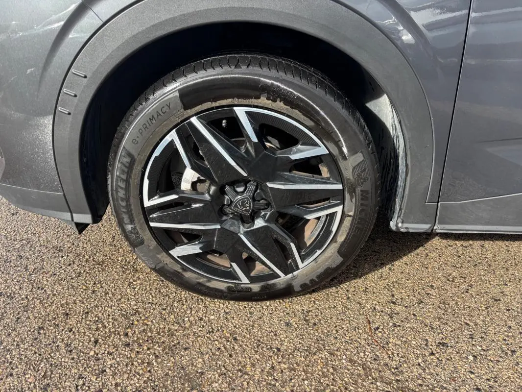 Gros plan sur la roue avant droite du Peugeot 3008 gris, jante alliage 19 pouces au design moderne.