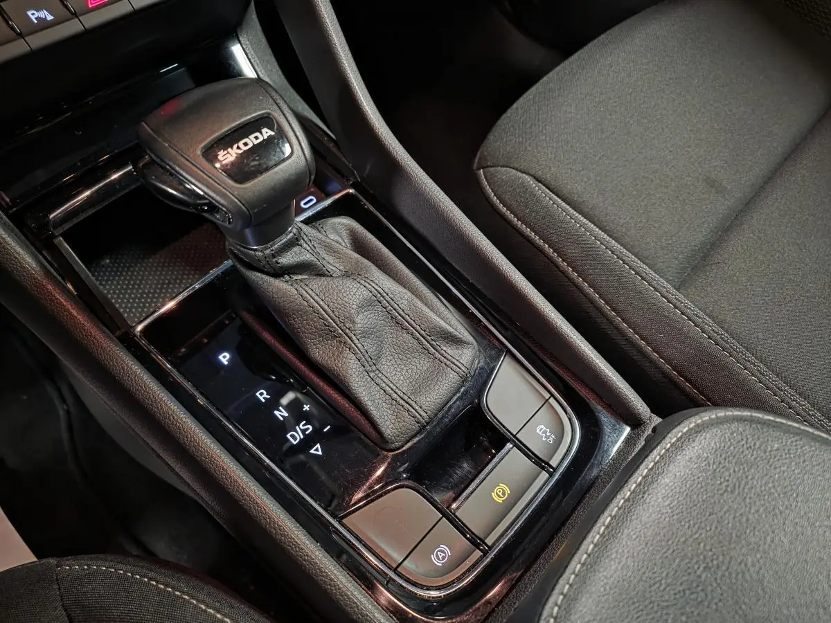 Gros plan sur la console centrale intérieure du Skoda Karoq 2024 avec levier de vitesse automatique en cuir noir.