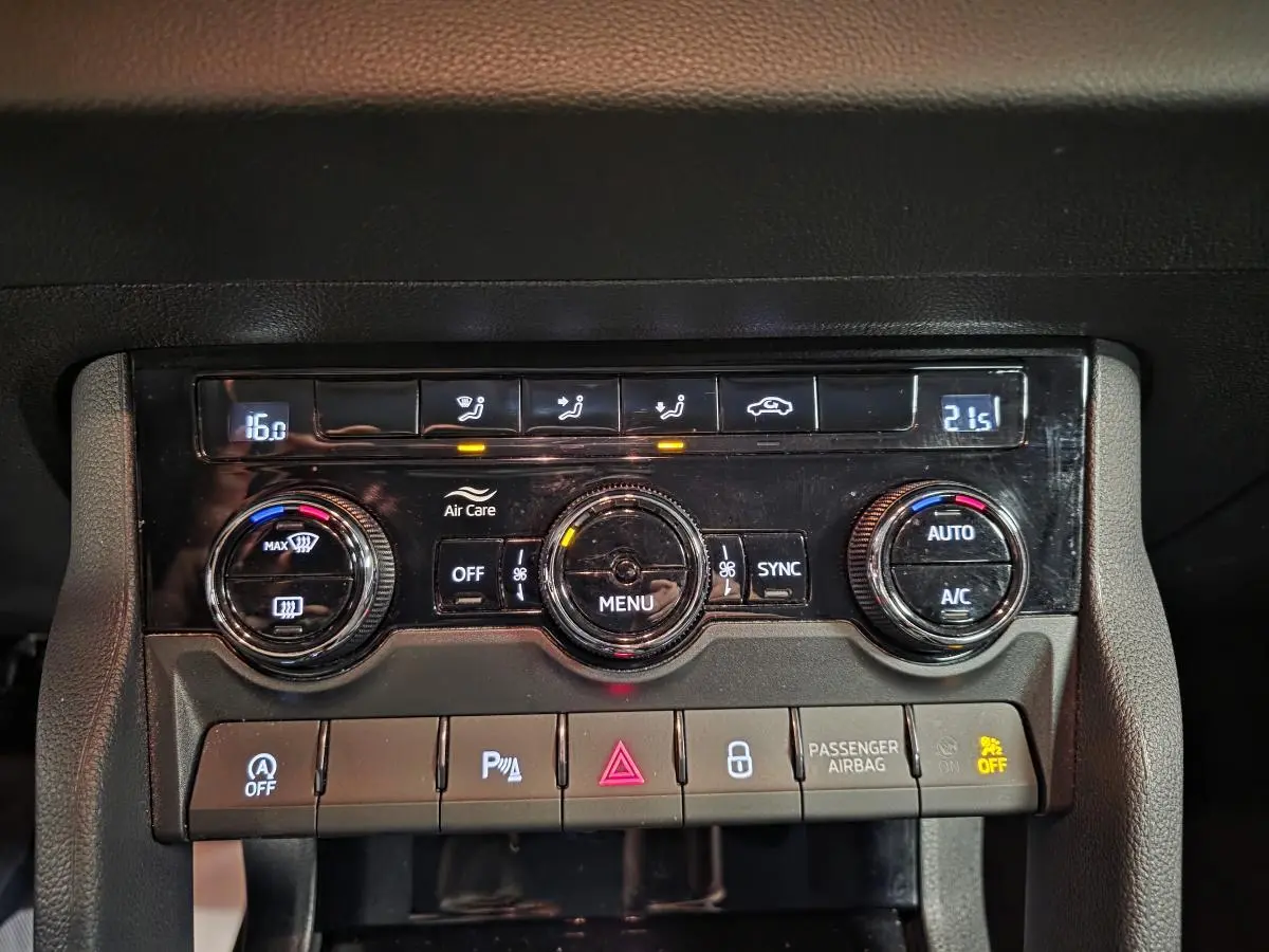 Gros plan sur la console centrale du Skoda Karoq 2024 avec commandes climatisation digitale et boutons fonctionnels.