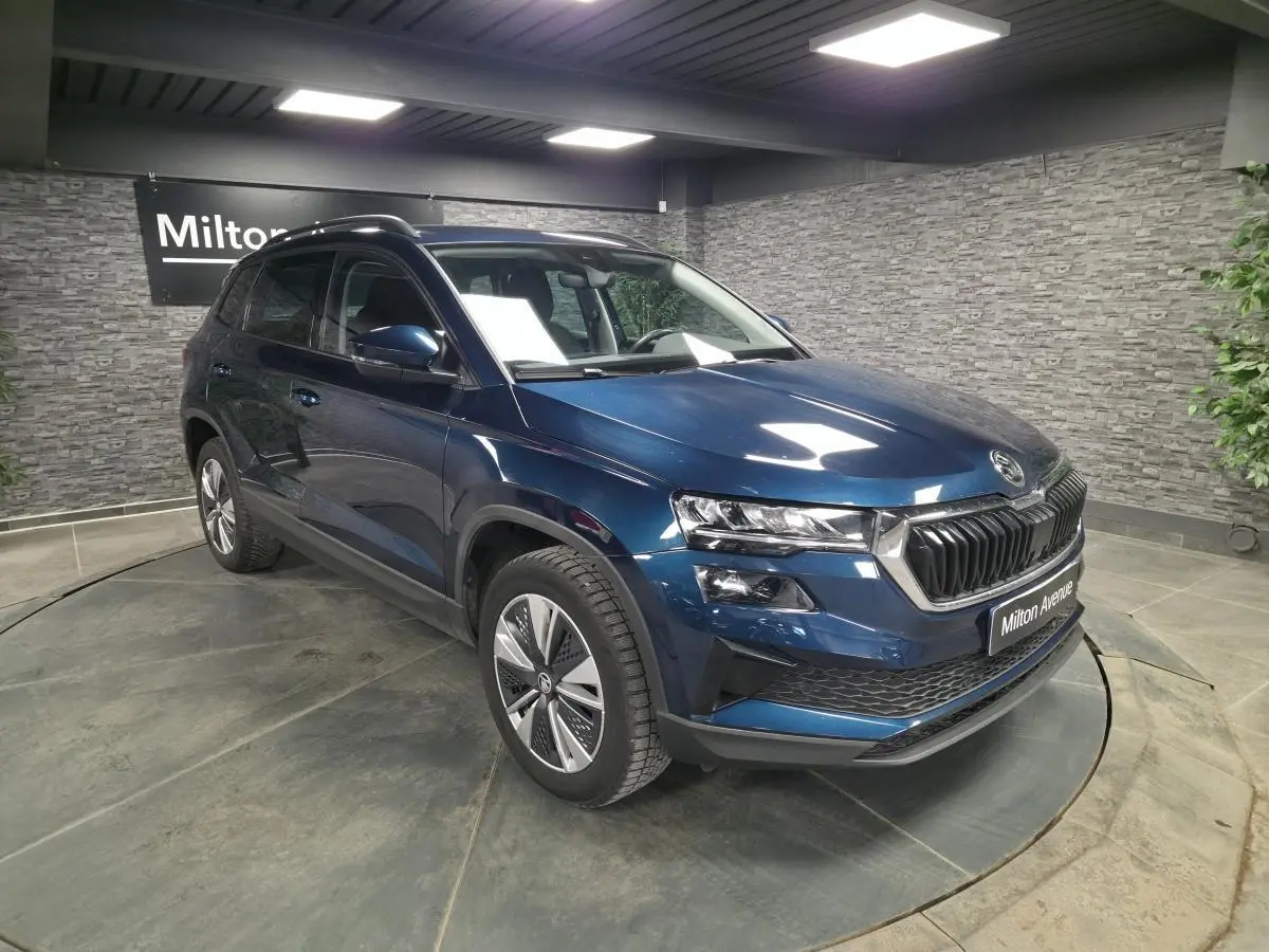 SKODA KAROQ bleu métallisé en 3/4 avant droit, avec calandre noire chromée et jantes alliage 17 pouces.