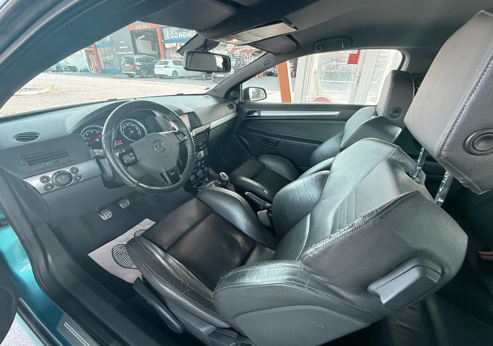 Intérieur noir cuir de l'Opel Astra OPC 2008, vue côté conducteur avec volant et sièges sport visibles.