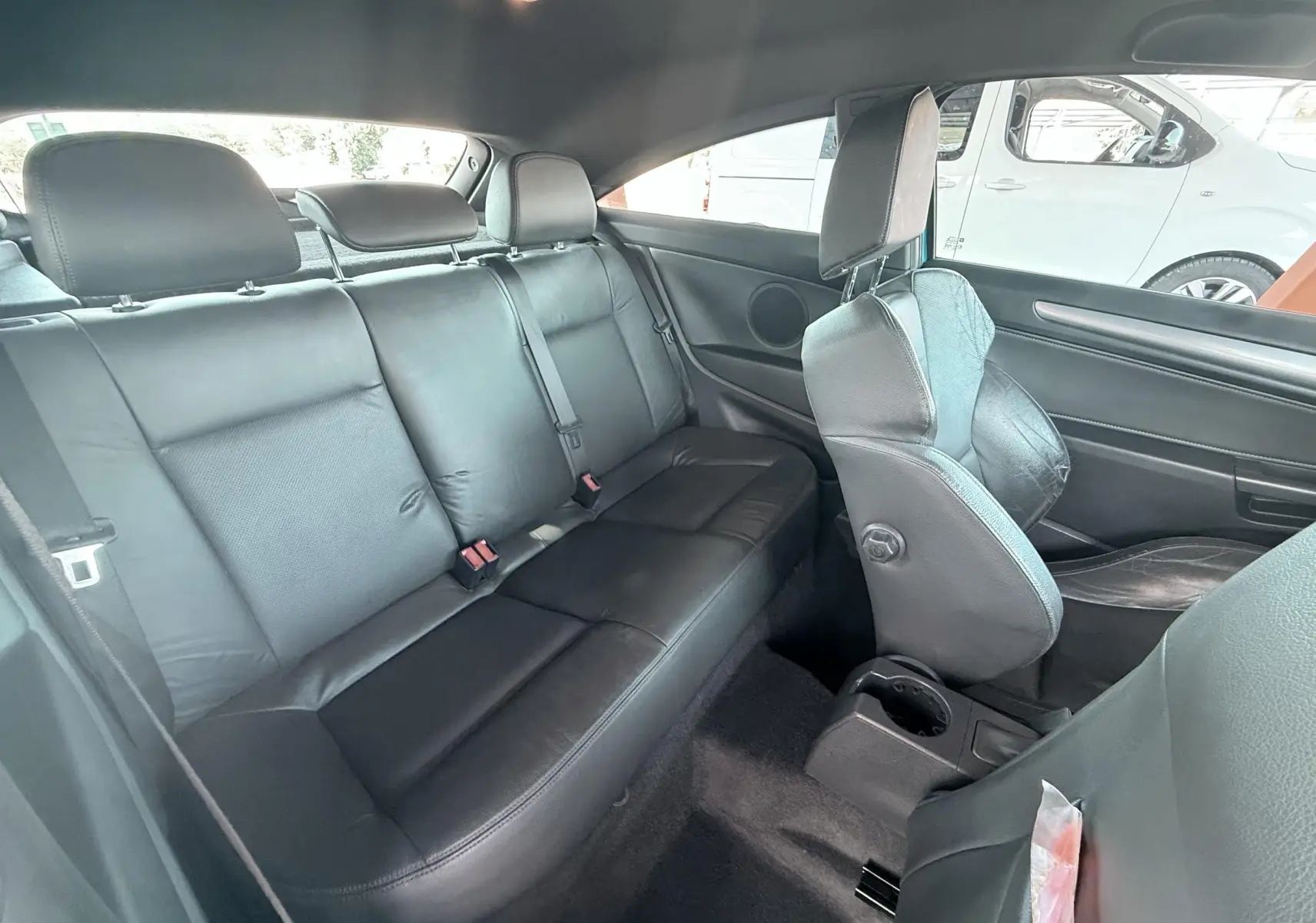 Vue intérieure arrière de l'Opel Astra OPC 2008 montrant les sièges en cuir noir et l'espace passager.