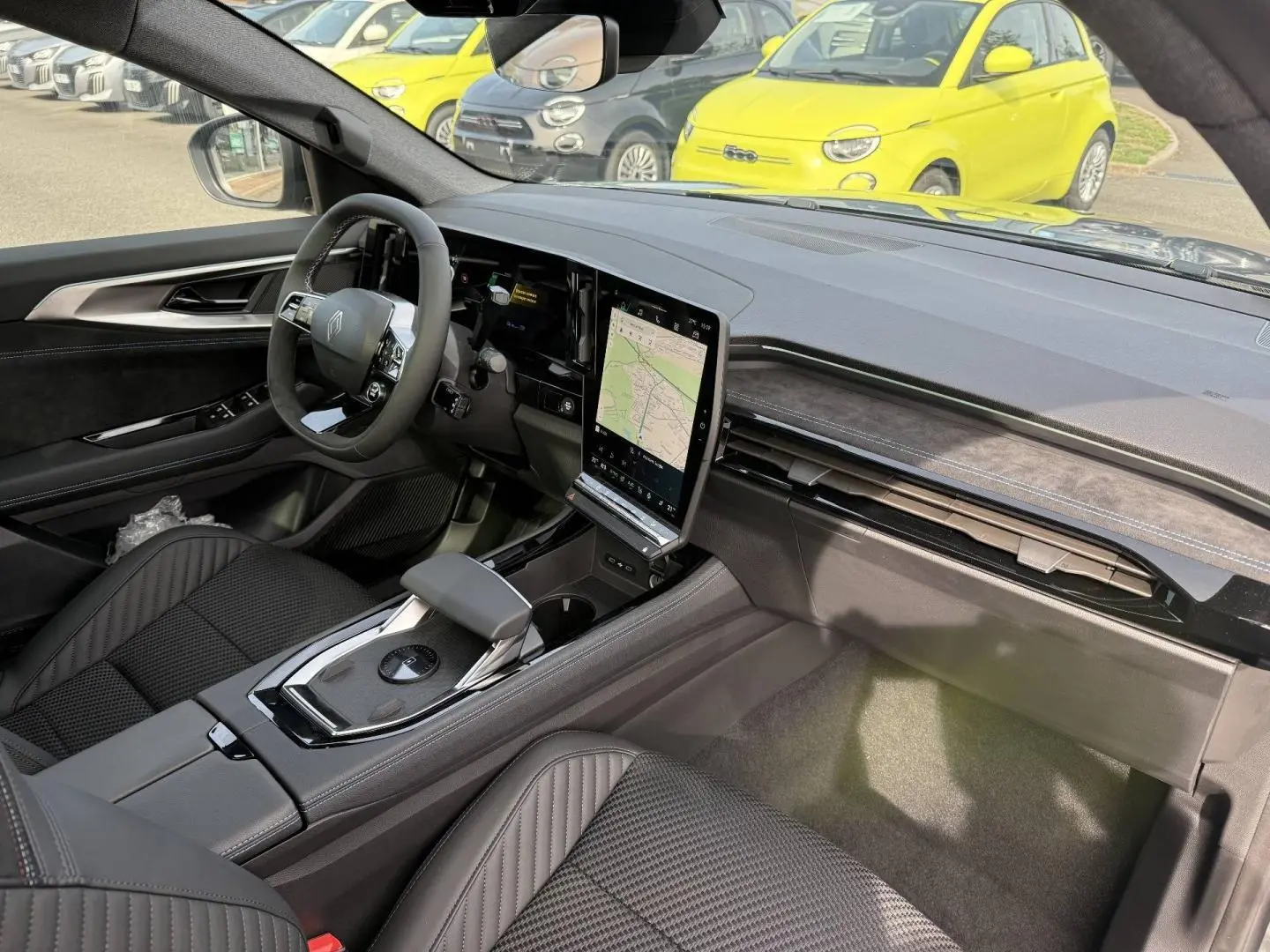 Vue intérieure côté conducteur du Renault Austral 2026, avec tableau de bord noir et écran tactile vertical.