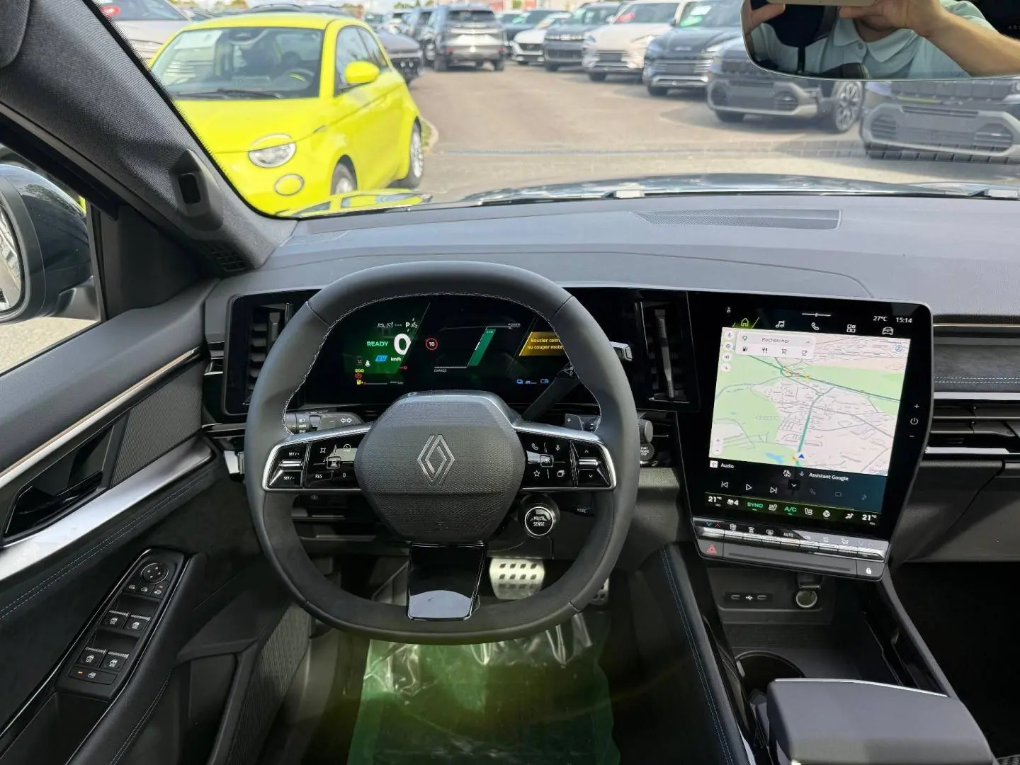 Vue intérieure du tableau de bord du Renault Austral 2026, volant multifonction et écran tactile central avec navigation visible.