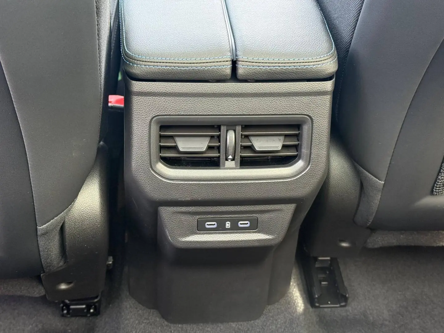 Vue rapprochée des aérateurs arrière et ports USB-C noirs sur la console centrale du Renault Austral gris Schiste satin.