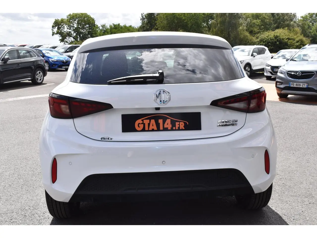 Vue arrière d'une MG3 1.5 HYBRID+ 195 LUXURY blanche de 2026 avec feux arrière sombres et logo MG central.