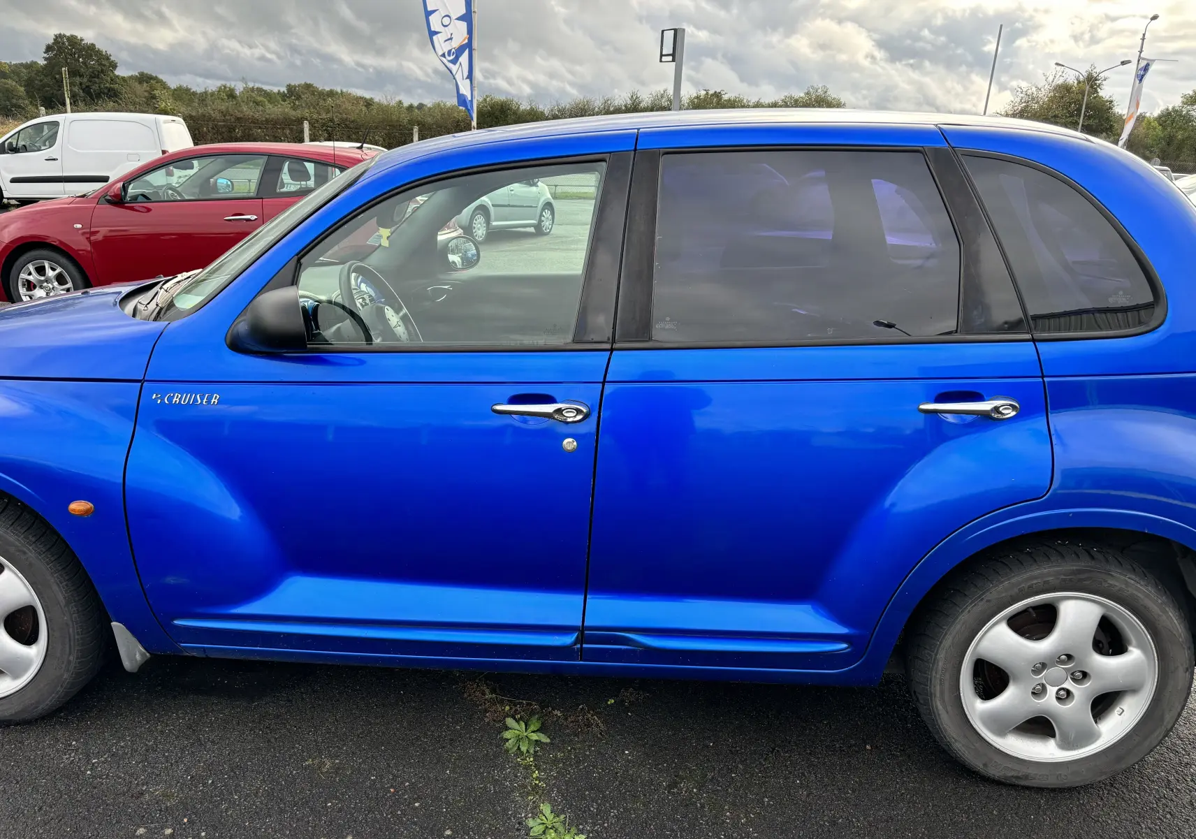 Vue latérale gauche d'une Chrysler PT Cruiser 2004 bleu vif avec ses poignées chromées distinctives.