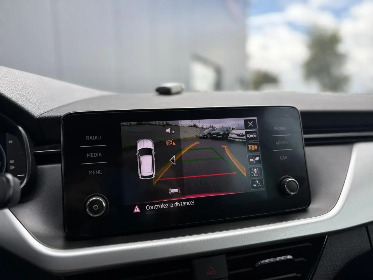 Écran tactile du tableau de bord du Skoda Kamiq rouge montrant la caméra de recul avec guidage dynamique.