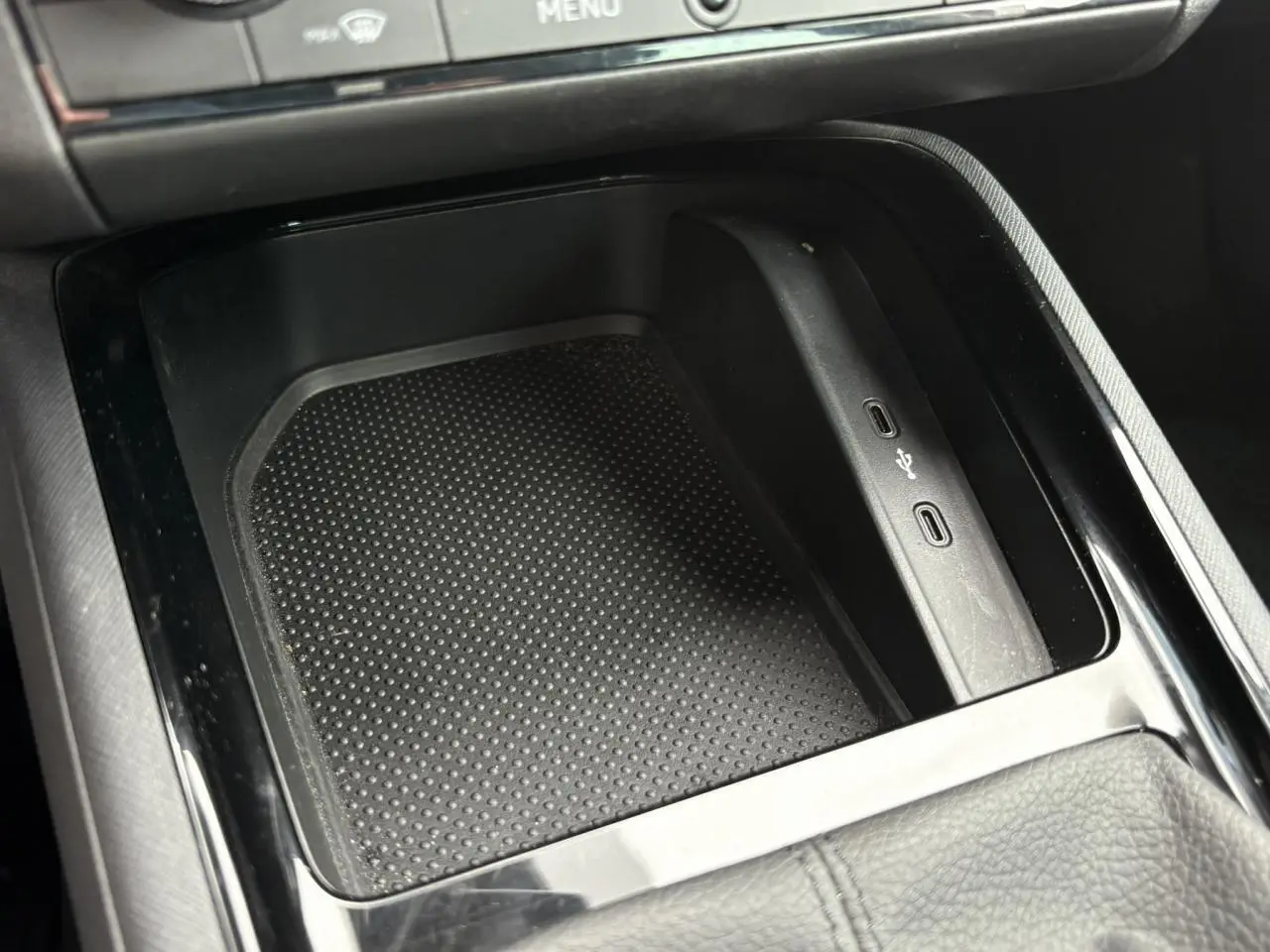 Gros plan sur la console centrale du Skoda Kamiq rouge Velvet 2024, montrant les ports USB et un espace de rangement noir texturé.