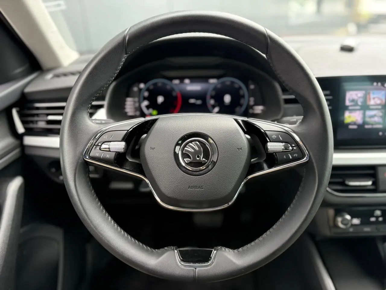 Volant cuir noir multifonctions de la Skoda Kamiq 2024 avec Digital Cockpit et écran tactile visible en arrière-plan.