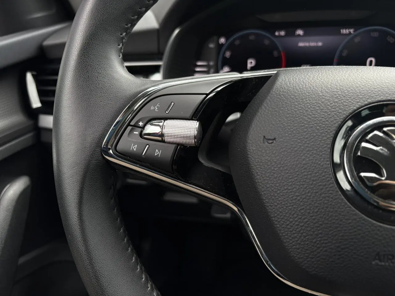Gros plan sur le volant cuir multifonctions du Skoda Kamiq 2024, avec commandes audio et Digital Cockpit en arrière-plan.