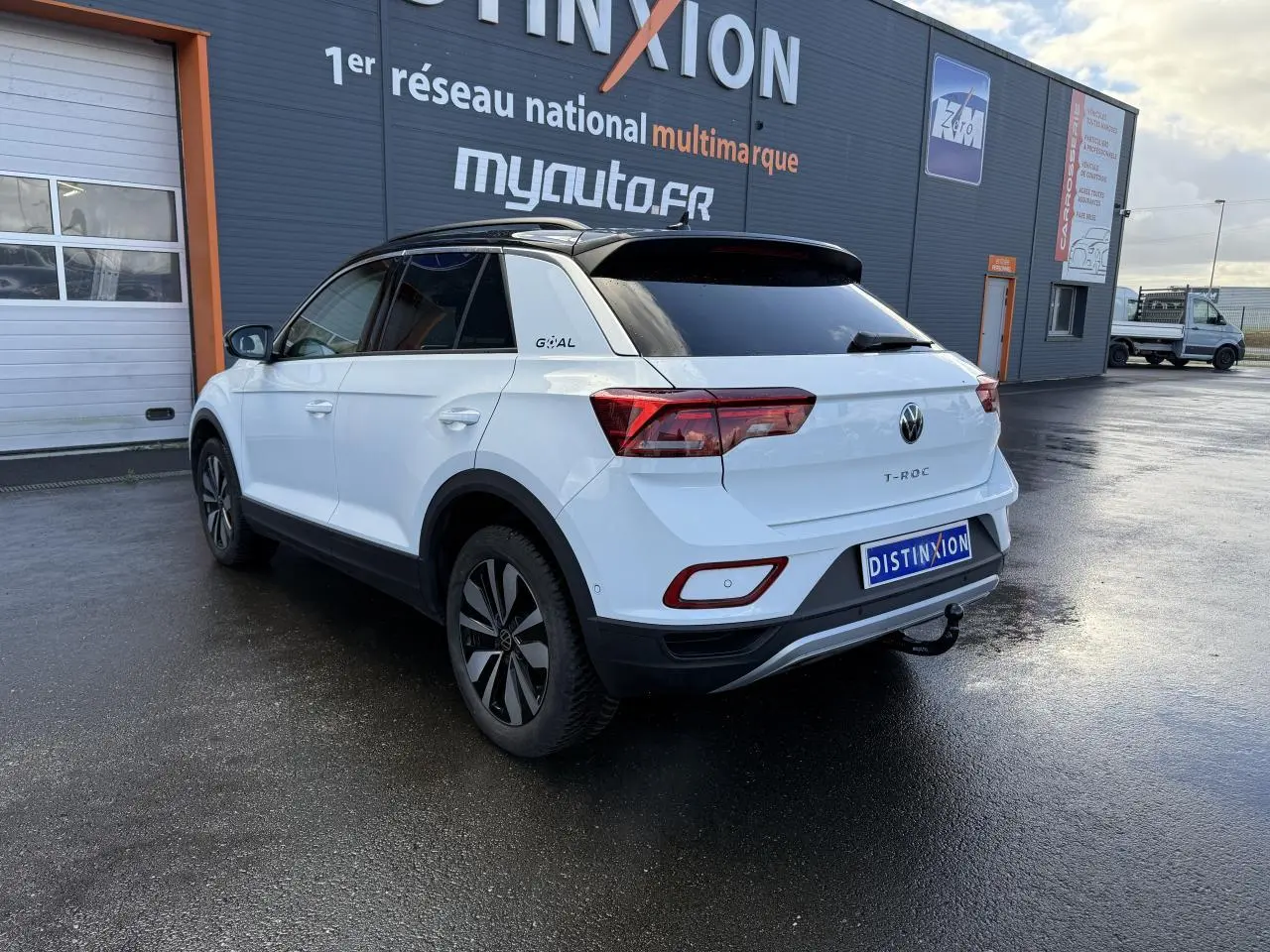 Vue 3/4 arrière droite du Volkswagen T-Roc blanc pur avec attelage amovible et jantes alliage Zürich 17 pouces.
