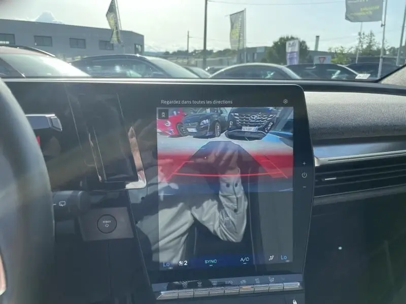 Vue intérieure du Renault Scénic E-Tech 2024 montrant l'écran central avec caméra de recul et tableau de bord moderne.