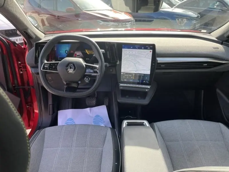 Vue intérieure avant du Renault Scenic E-Tech Electric rouge flamme 2024, avec tableau de bord numérique et écran tactile central.