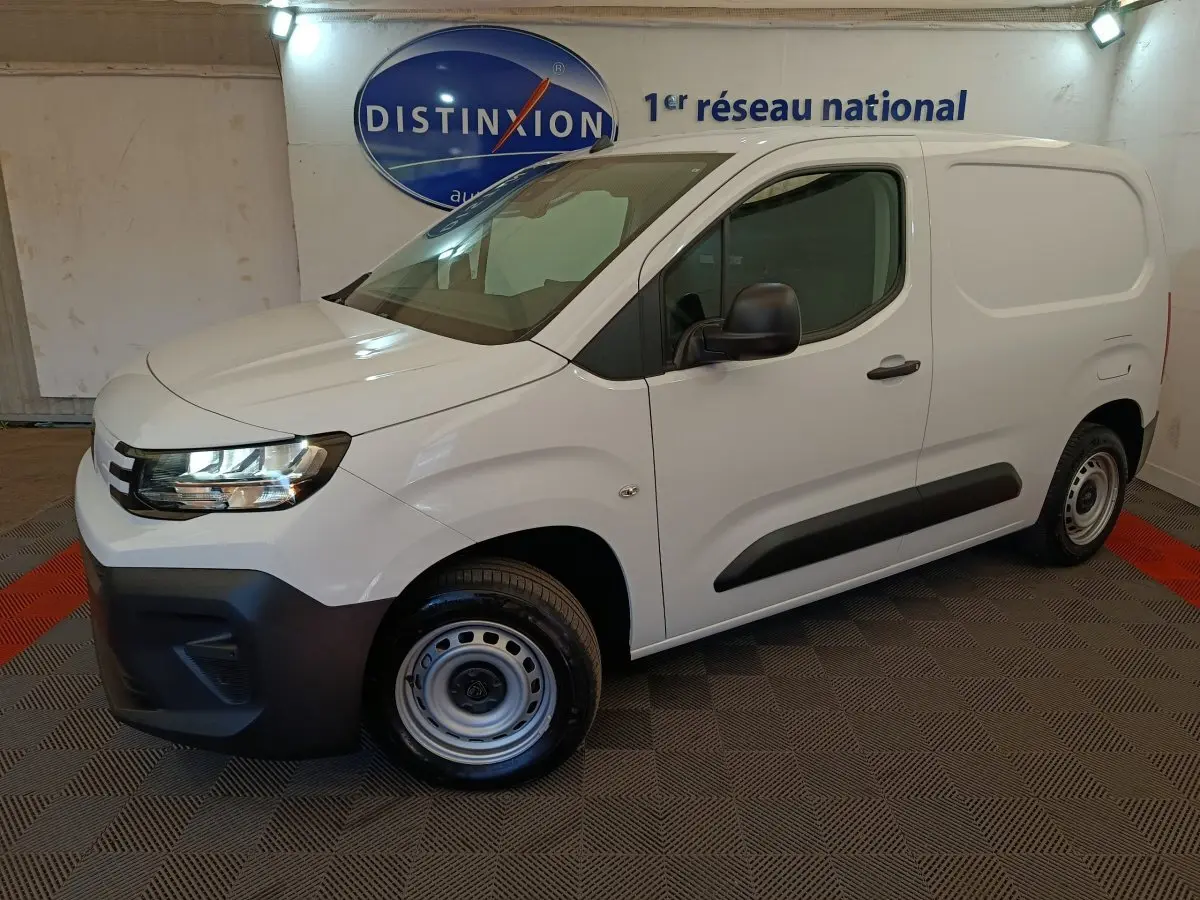 Peugeot Partner blanc vue 3/4 avant droit, fourgon utilitaire avec protections latérales noires et jantes acier.
