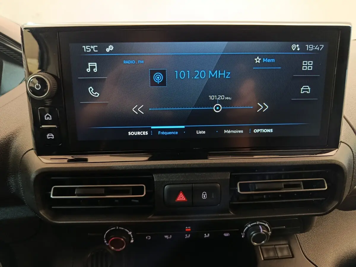 Gros plan sur l’écran tactile central du Peugeot Partner 2025 affichant la radio FM à 101,20 MHz, avec commandes et aérateurs.