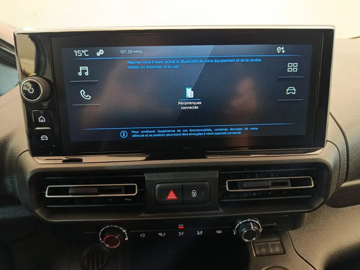 Écran tactile central et commandes de climatisation du tableau de bord du Peugeot Partner 2025, intérieur noir.