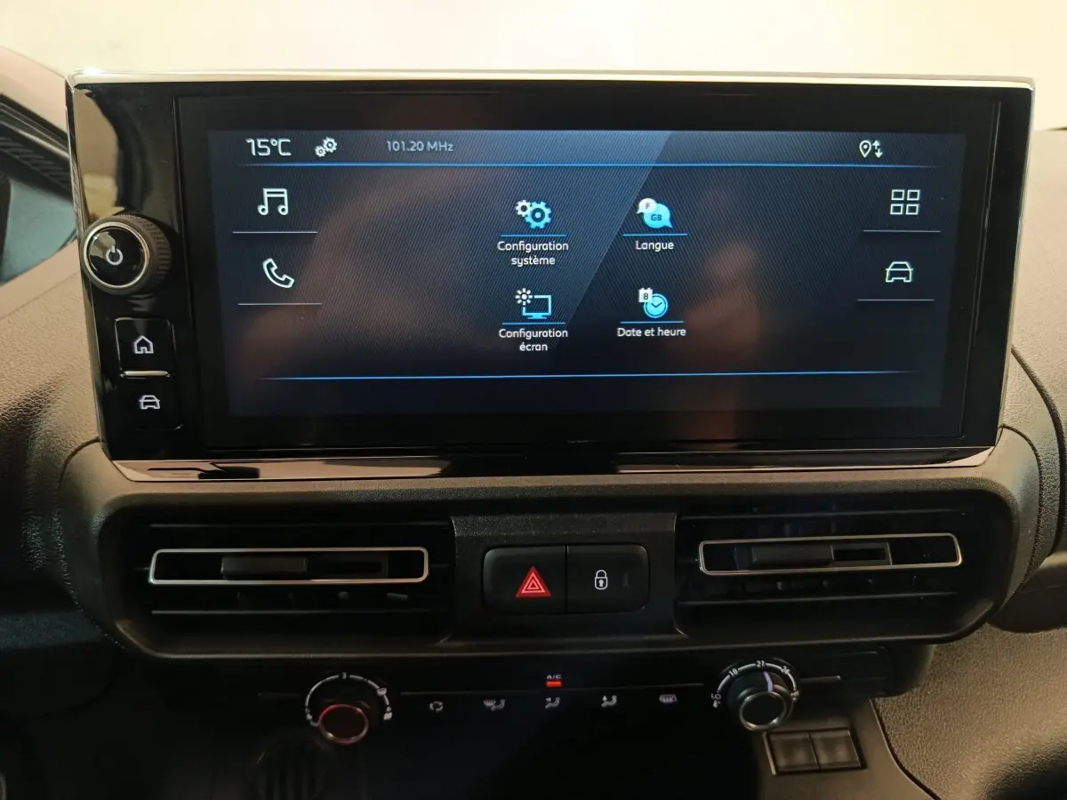 Écran tactile central du tableau de bord du Peugeot Partner 2025 avec commandes de climatisation et boutons d’alerte visibles.