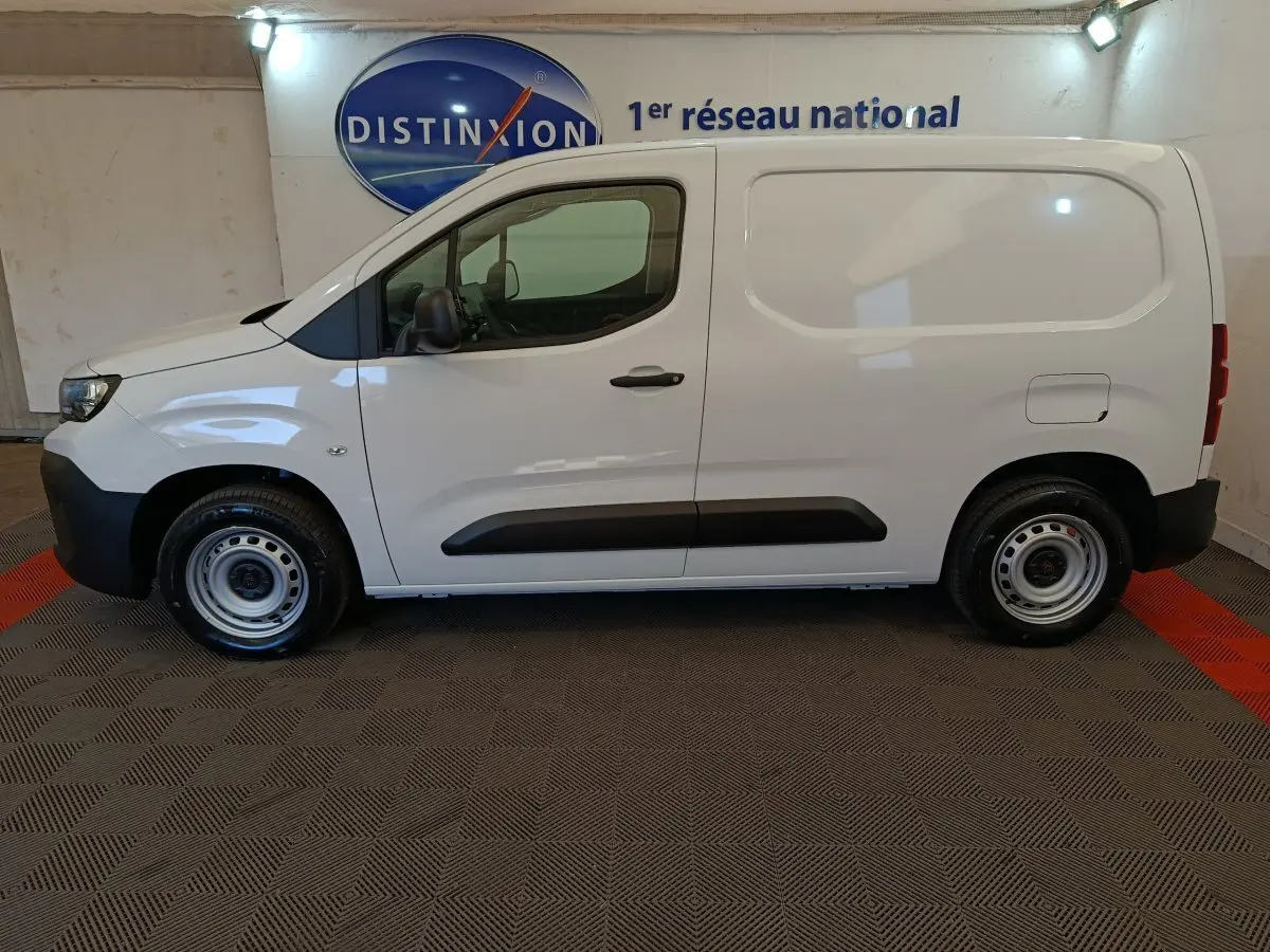 Vue de profil côté gauche d'un Peugeot Partner blanc 2025, utilitaire compact avec porte latérale pleine.