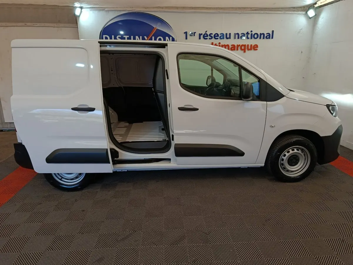 Vue latérale droite d'un Peugeot Partner blanc 2025 avec porte coulissante ouverte montrant l'espace de chargement.