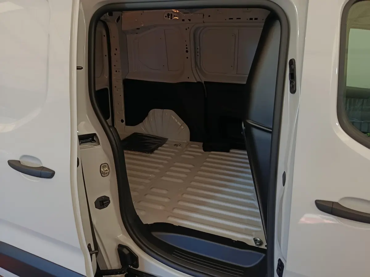 Vue intérieure du coffre blanc du Peugeot Partner Taille M 650kg, montrant l'espace de chargement vide avec cloison pleine.