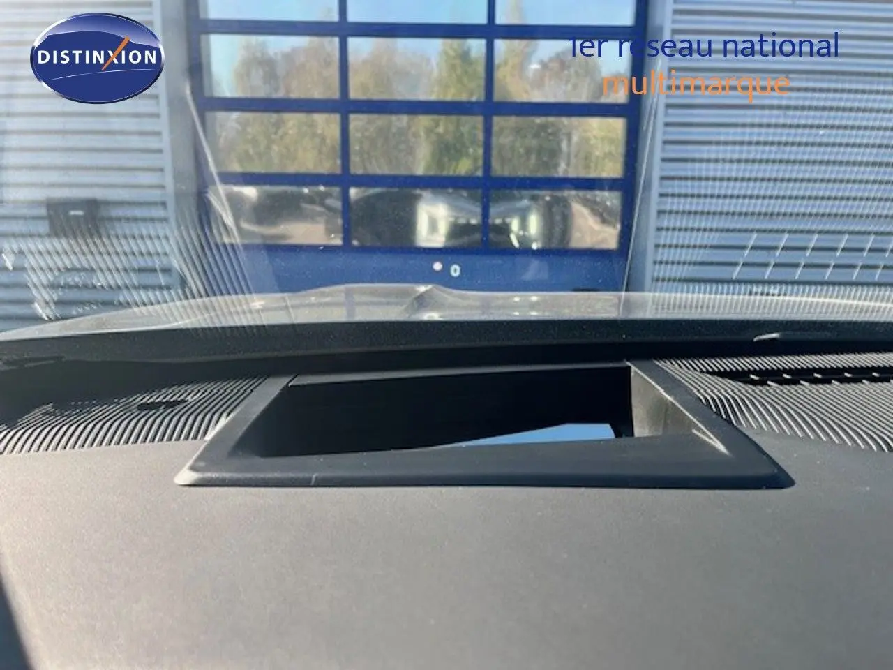 Vue intérieure du tableau de bord du Jeep Compass 2026, avec écran escamotable et pare-brise en arrière-plan.