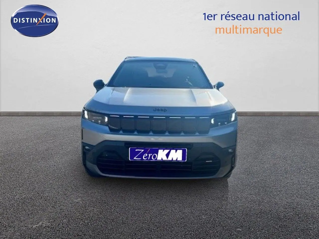 Vue frontale d'un Jeep Compass 2026 gris Yosemite métal avec toit noir, calandre noire et feux LED allumés.