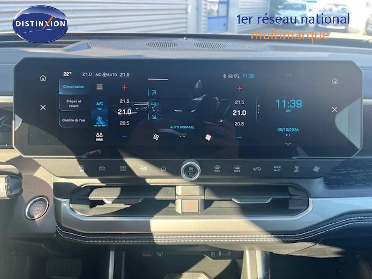 Vue intérieure du tableau de bord du Jeep Compass 2026, écran tactile large affichant la climatisation et l'heure.