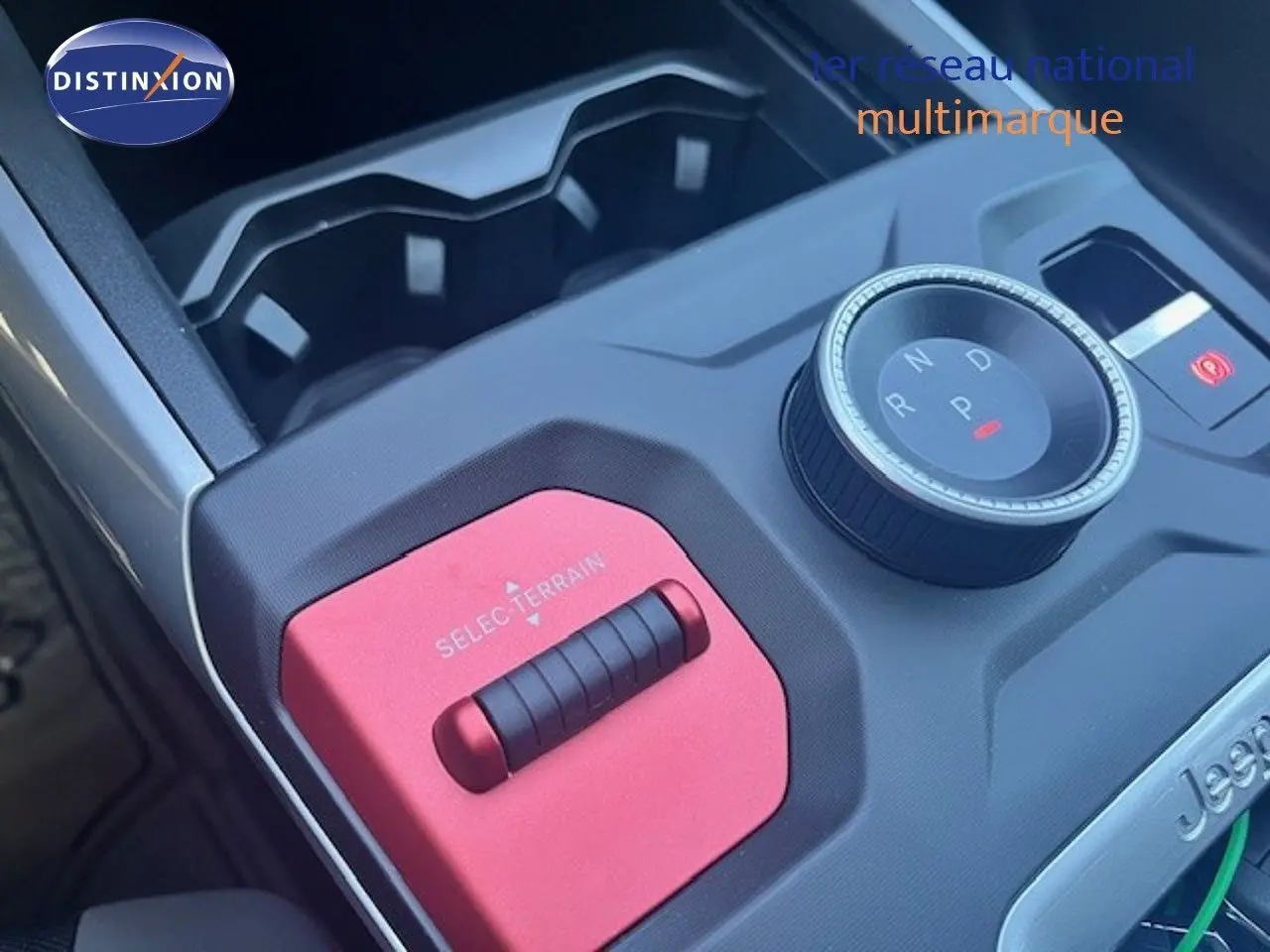 Gros plan sur la console centrale du Jeep Compass 2026, avec molette de boîte auto et sélecteur de terrain rouge.