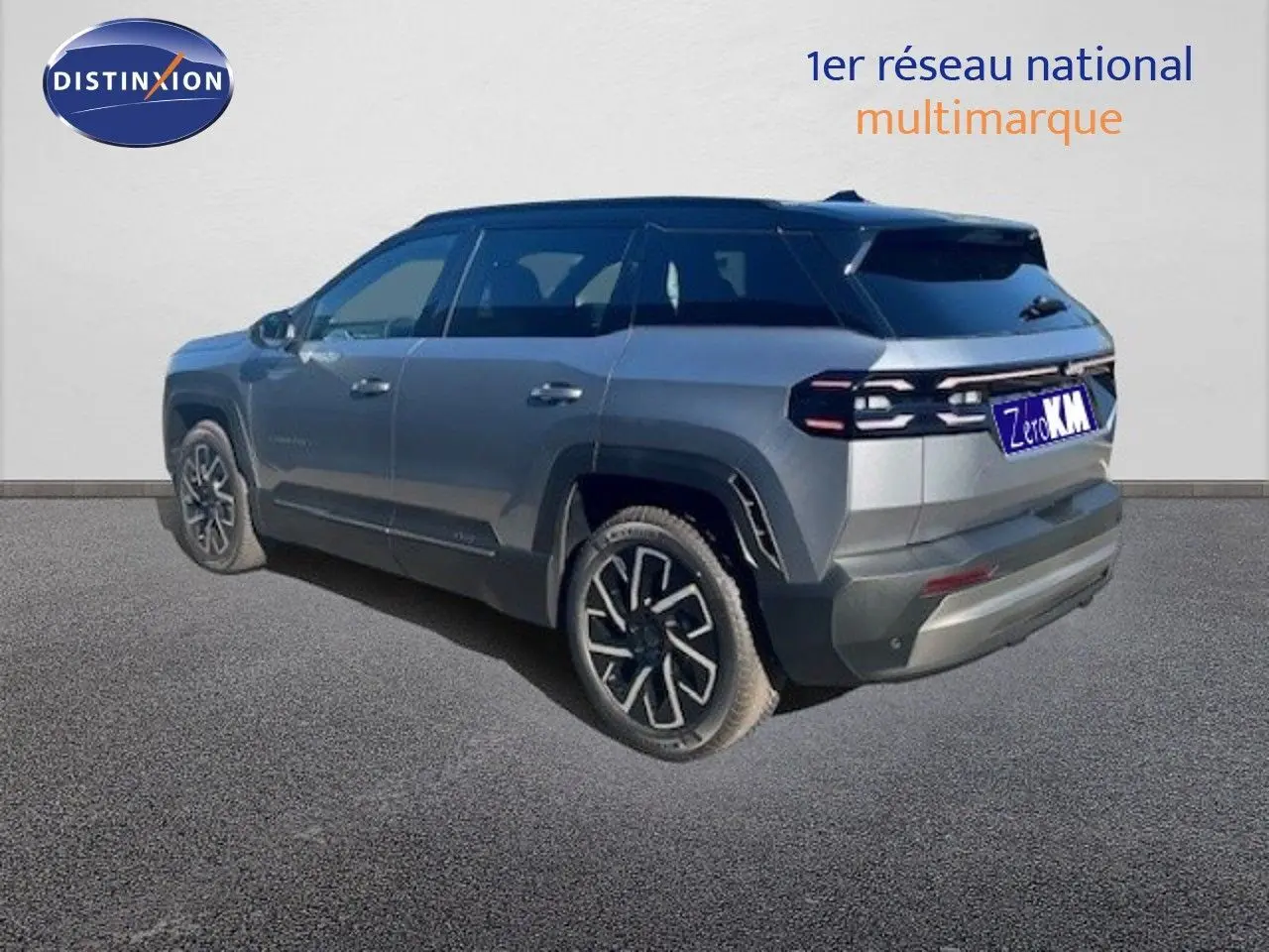 Vue 3/4 arrière droite du Jeep Compass gris Yosemite métal avec toit noir et jantes distinctives noires et argentées.