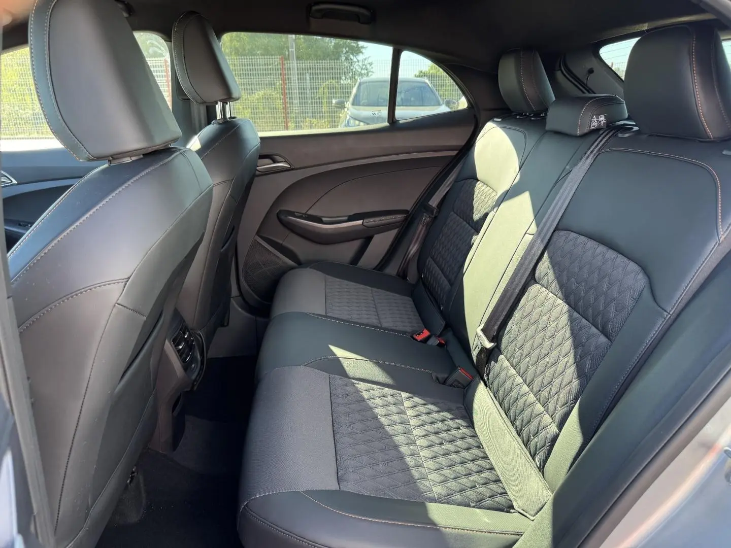 Vue latérale droite de l’habitacle arrière du MG3 1.5 Hybrid+ 195ch Luxury avec sièges en similicuir noir et tissu.