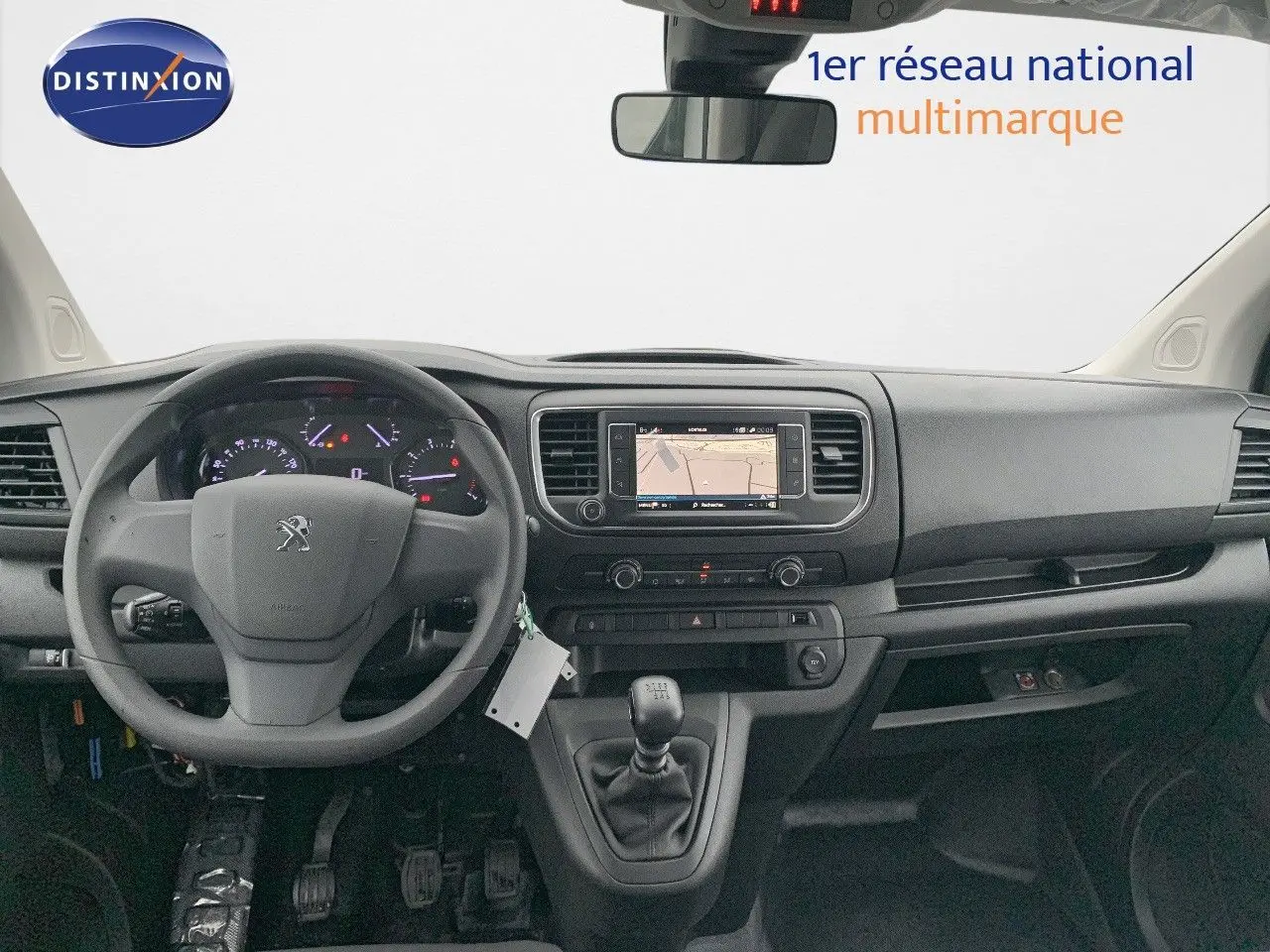 Vue intérieure frontale du tableau de bord noir du Peugeot Expert Cabine Approfondie blanc, avec volant, écran GPS et boîte manuelle.