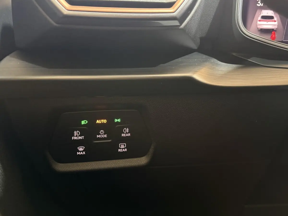 Gros plan sur les commandes d'éclairage avec affichage digital dans le tableau de bord du CUPRA Formentor noir 2023.