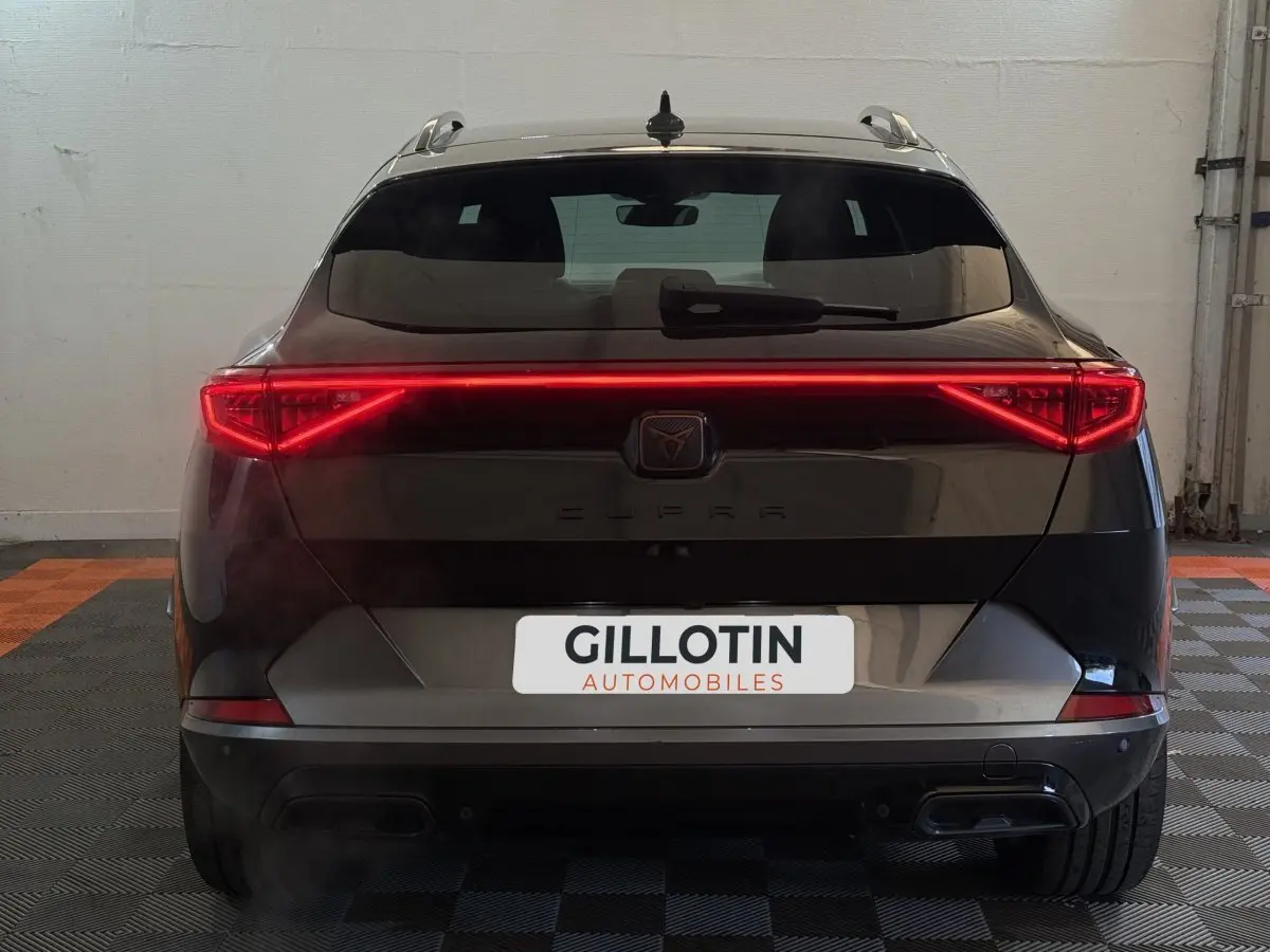 Vue arrière d'un CUPRA Formentor noir avec feux LED allumés et double sortie d'échappement visible.