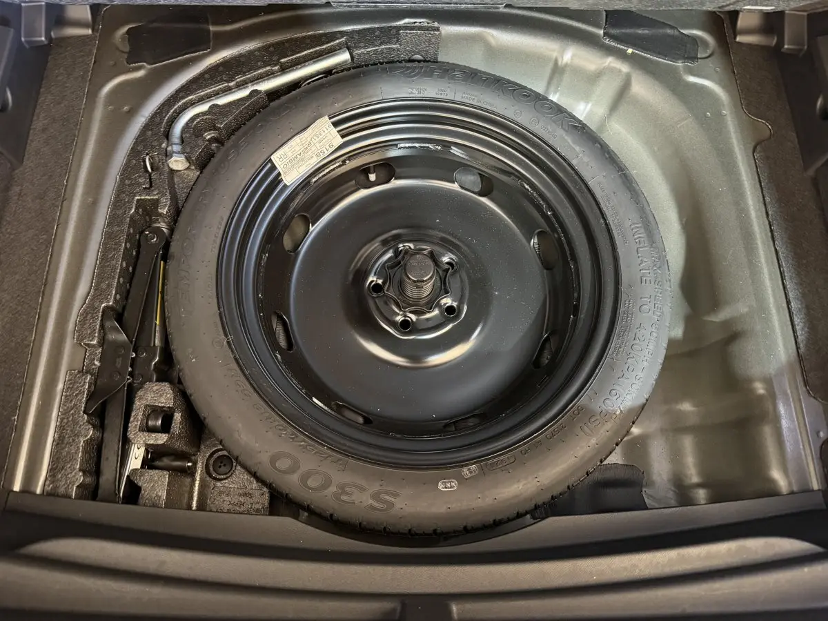 Gros plan sur la roue de secours galette noire dans le coffre du CUPRA Formentor 1.5 TSI 2023 noir.