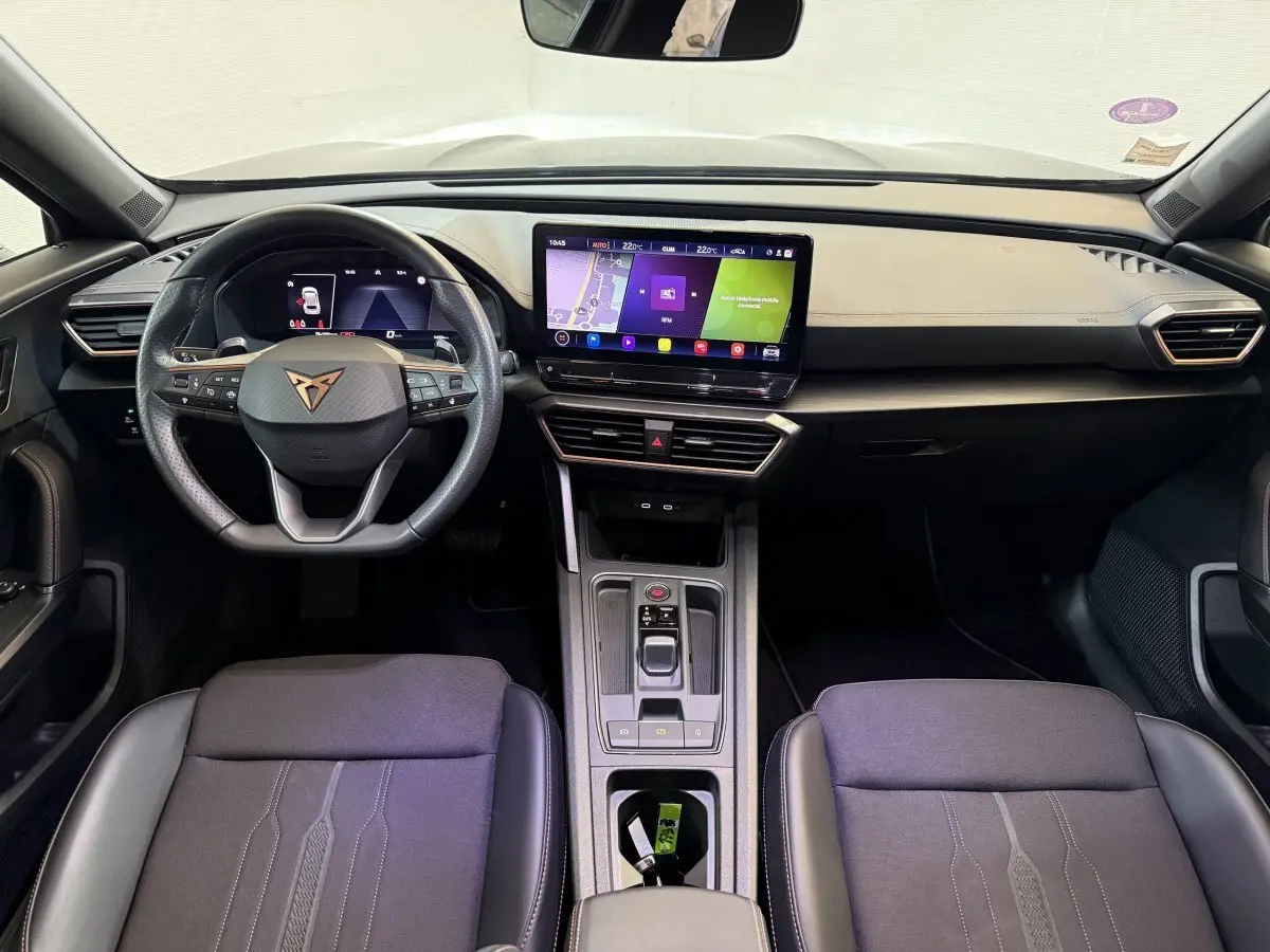 Intérieur de la CUPRA Formentor 2023 vu de face, tableau de bord noir avec écran tactile central et volant cuir.