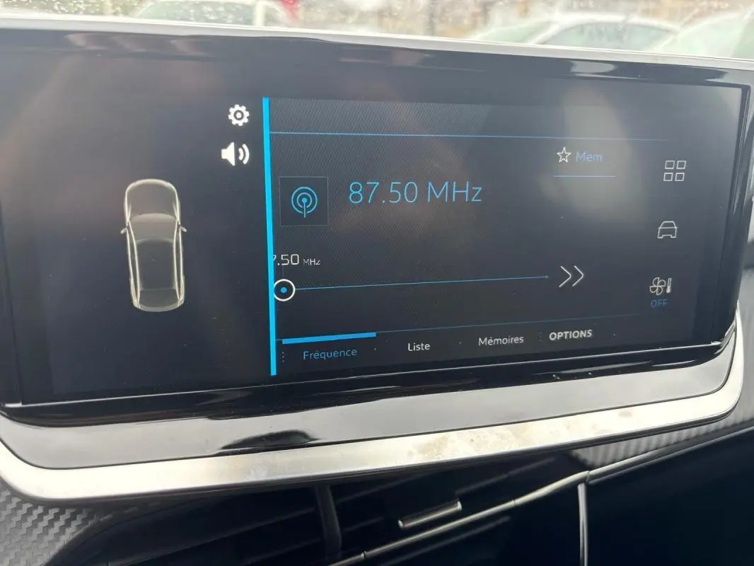 Écran tactile central de la Peugeot 208 Hybrid 100 e-DCS6 Style 2025 affichant une fréquence radio à 87,50 MHz.