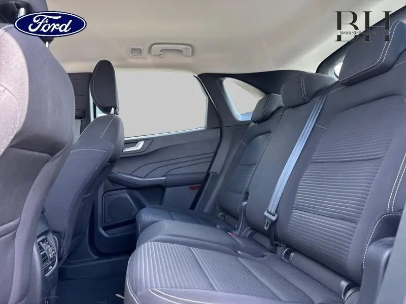 Vue latérale intérieure des sièges arrière noirs avec surpiqûres blanches du Ford Kuga 2023 gris Solar Métallisé.