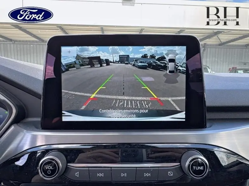 Écran tactile intérieur du Ford Kuga 2023 affichant la caméra de recul avec guidage coloré et vue arrière du parking.
