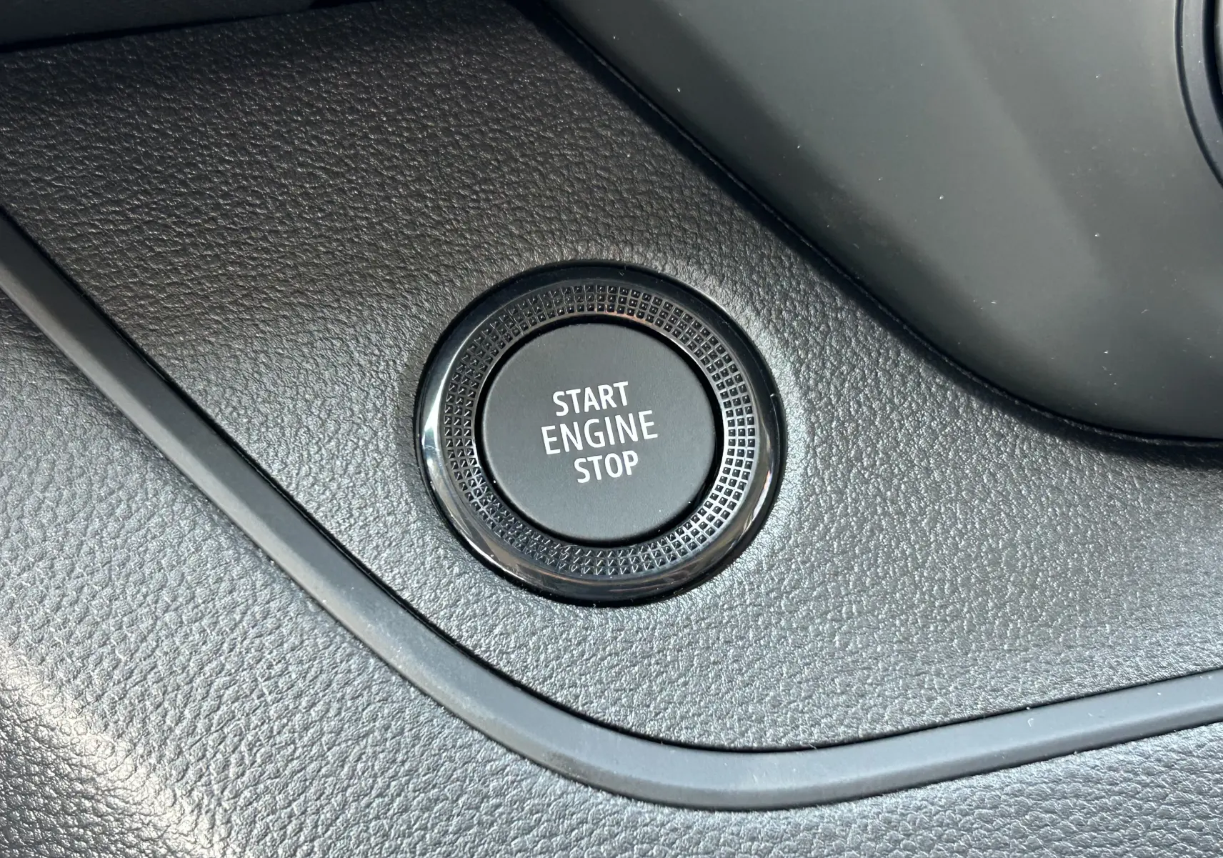 Bouton start engine stop en gros plan sur le tableau de bord noir du Renault Trafic cabine approfondie blanc.