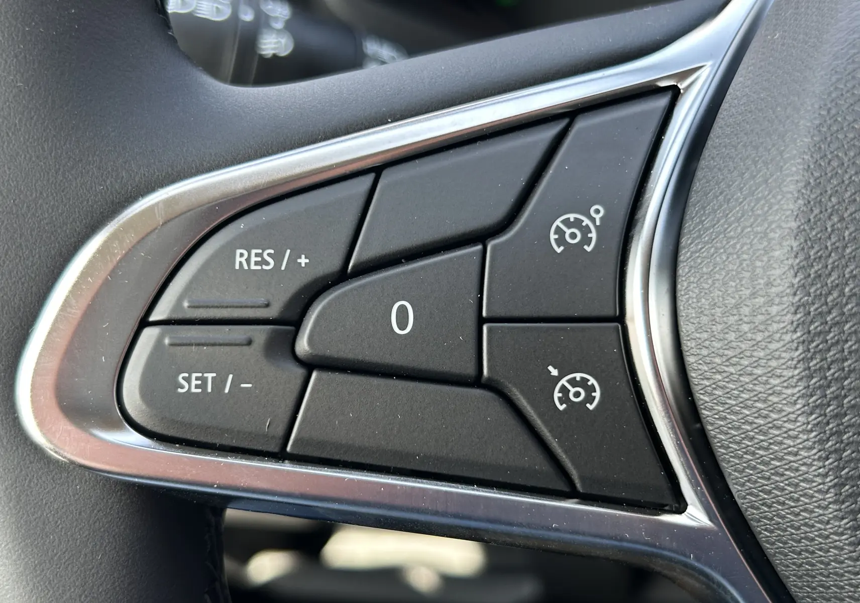 Gros plan sur les commandes de régulateur de vitesse au volant d’un Renault Trafic blanc, finition 2026.