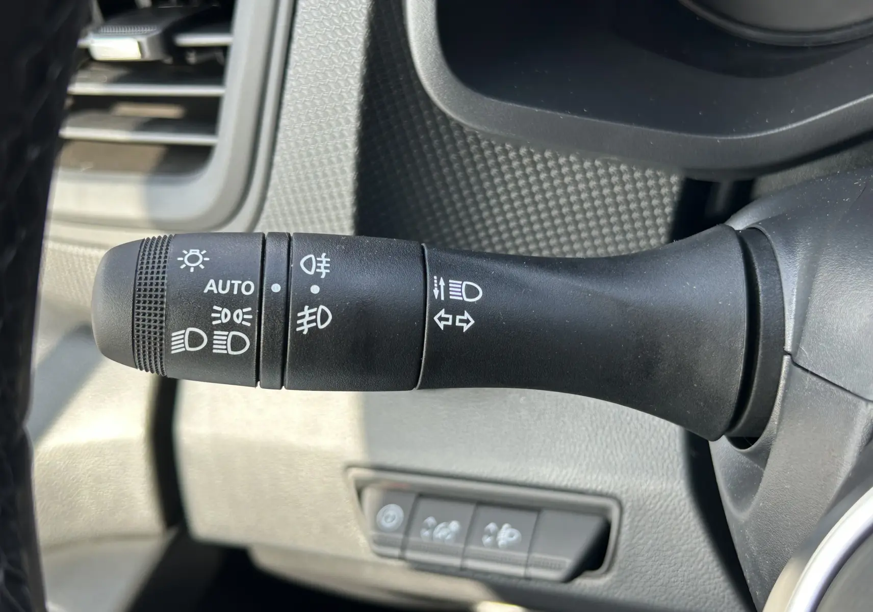 Gros plan sur la commande des feux et clignotants dans l’habitacle du Renault Trafic blanc, côté gauche du volant.