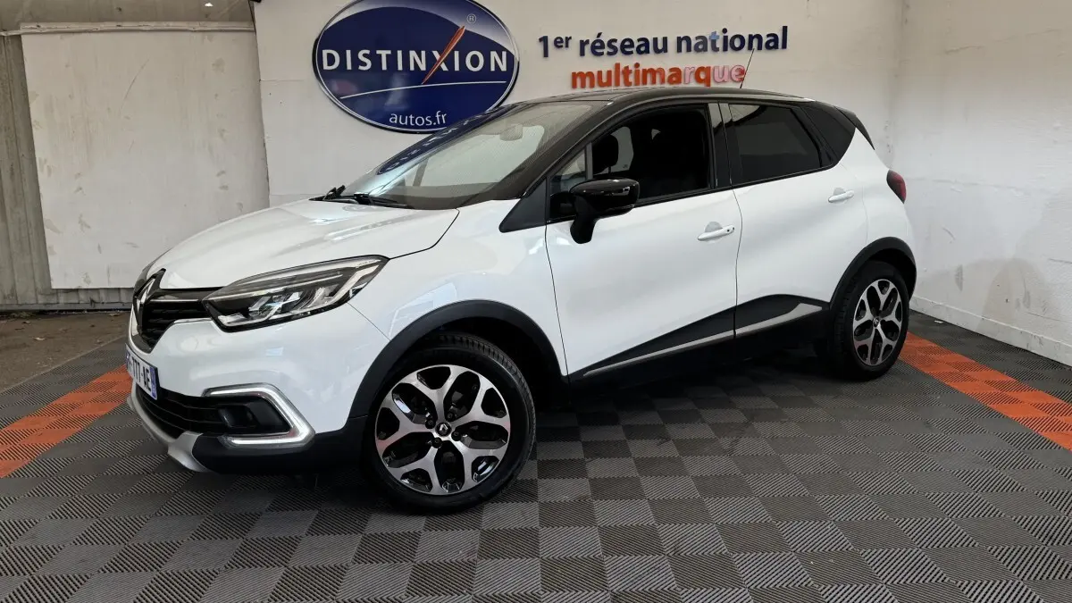 Renault Captur Intens TCe 90 blanc en 3/4 avant droit, avec jantes alliage et détails noirs contrastants.