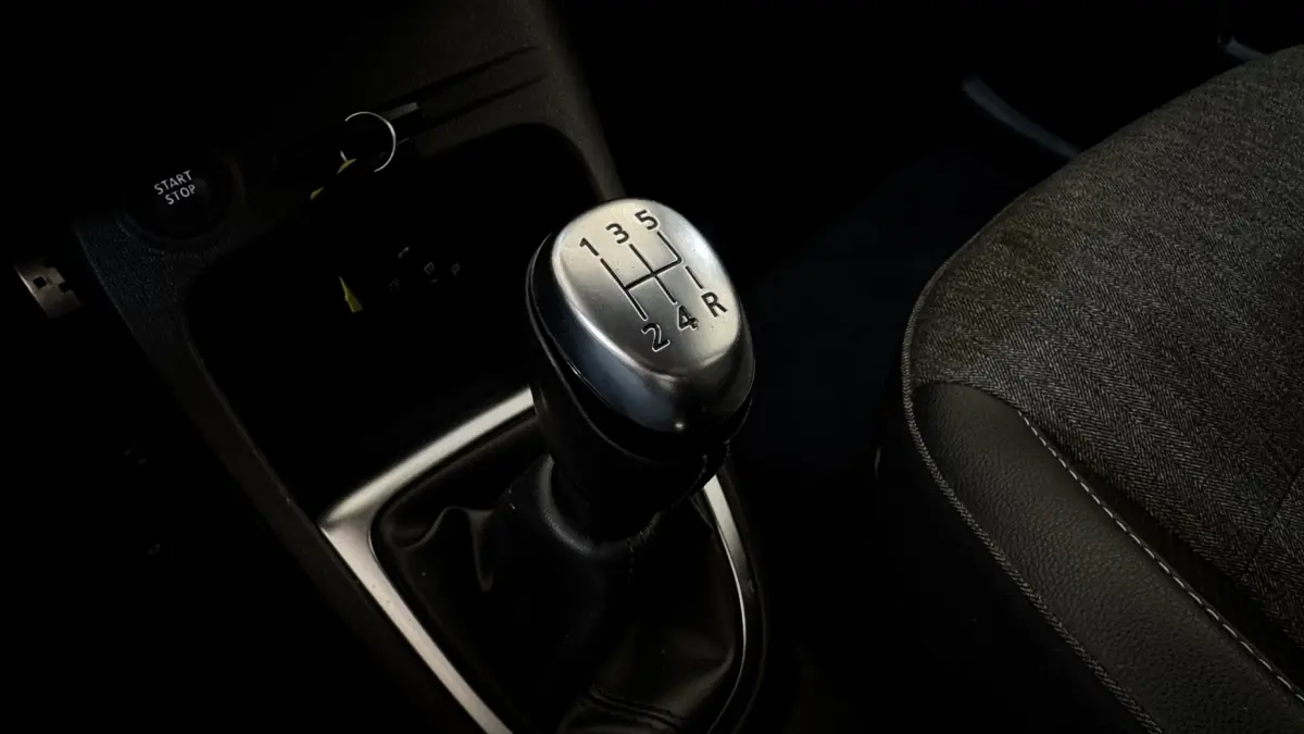 Gros plan sur le levier de vitesse manuel argenté du Renault Captur Intens 2019, siège tissu gris à côté.
