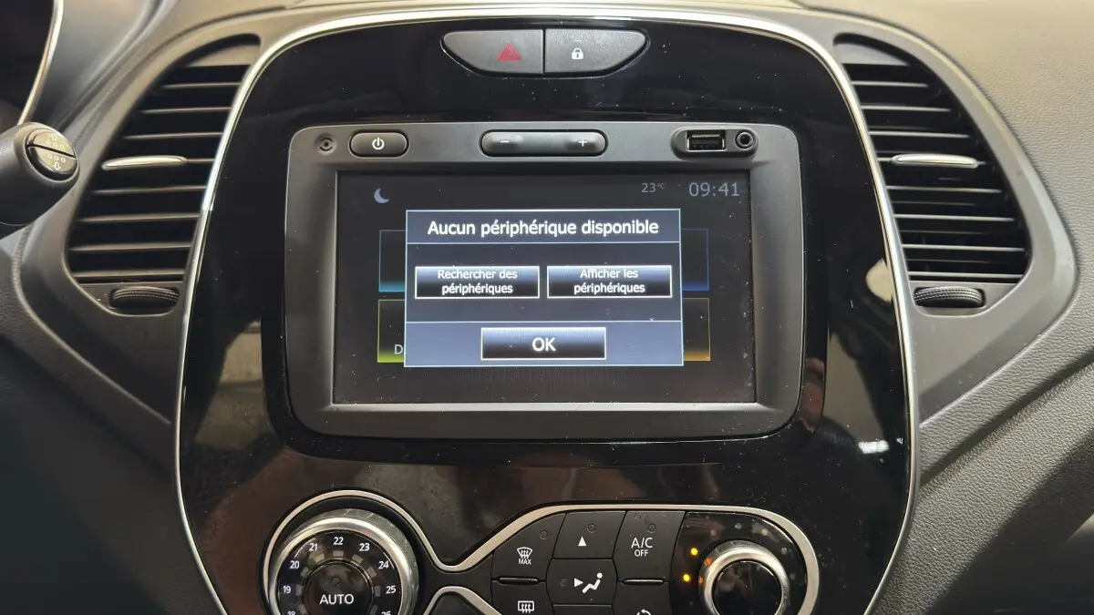 Gros plan sur l’écran tactile central noir du tableau de bord du Renault Captur blanc, affichant un message Bluetooth.