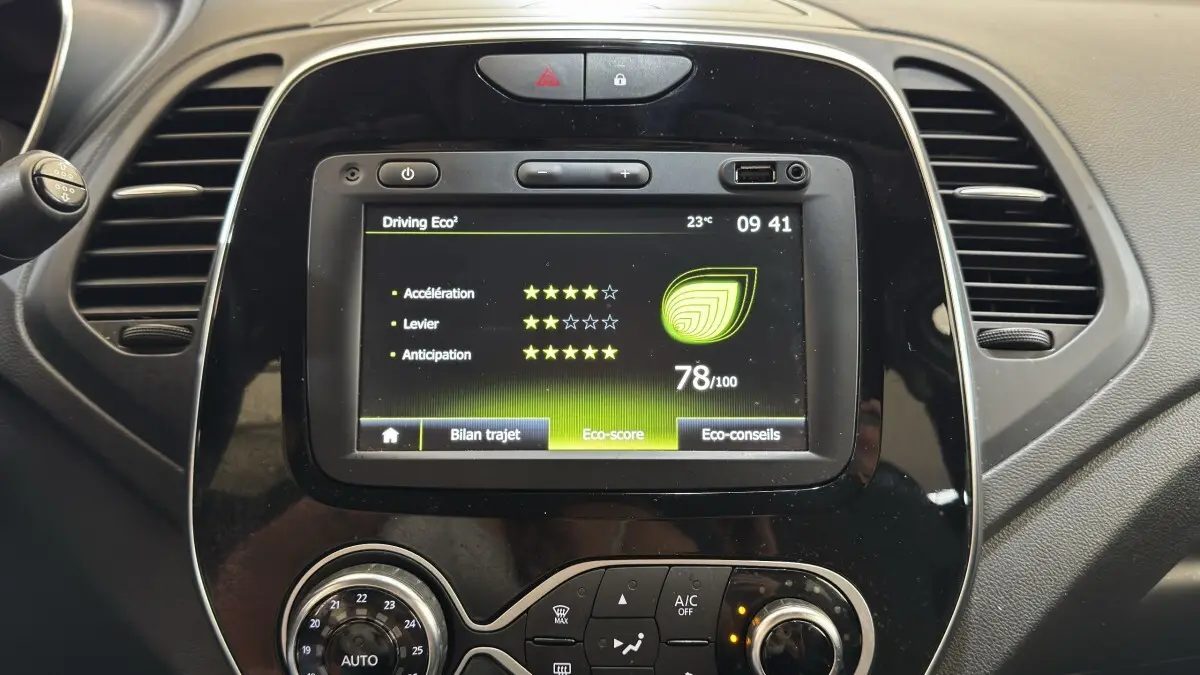 Vue rapprochée du tableau de bord noir du Renault Captur blanc 2019 avec écran tactile affichant l’éco-score.